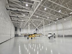 Photo of the hangar at the Saratoga County Airport. This view shows a large open space with two planes inside.
