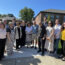 Group photo of the FM team with the building committee outside the entrance of the Caryl Community Center on a bright summer day.